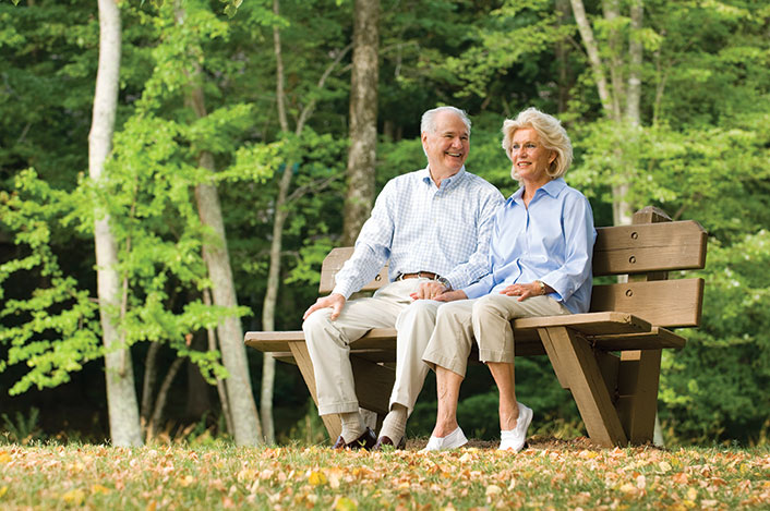 A couple resting on a bench together. Links to Gifts from Retirement Plans