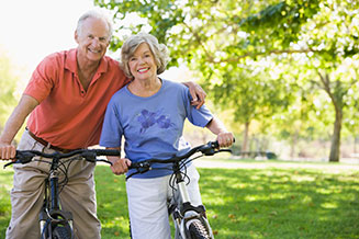 Photo of a man and woman on bicycles. Link to Life Stage Gift Planner Ages 60-70 Situations.